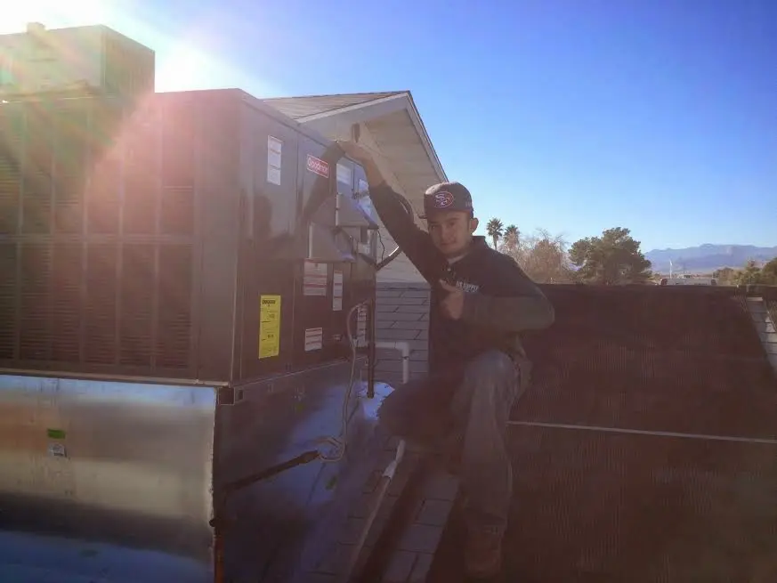 HVAC technician performing AC Tune-Up on a rooftop unit in Crystal Lake